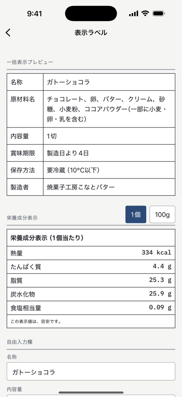 原価ノートの表示ラベル画面。一括表示の枠に名称・原材料名・内容量・賞味期限・保存方法・製造者が並び、原材料名の末尾に「（一部に小麦・卵・乳を含む）」。下に栄養成分表示（1個当たり）の枠と「この表示値は、目安です。」の一文。